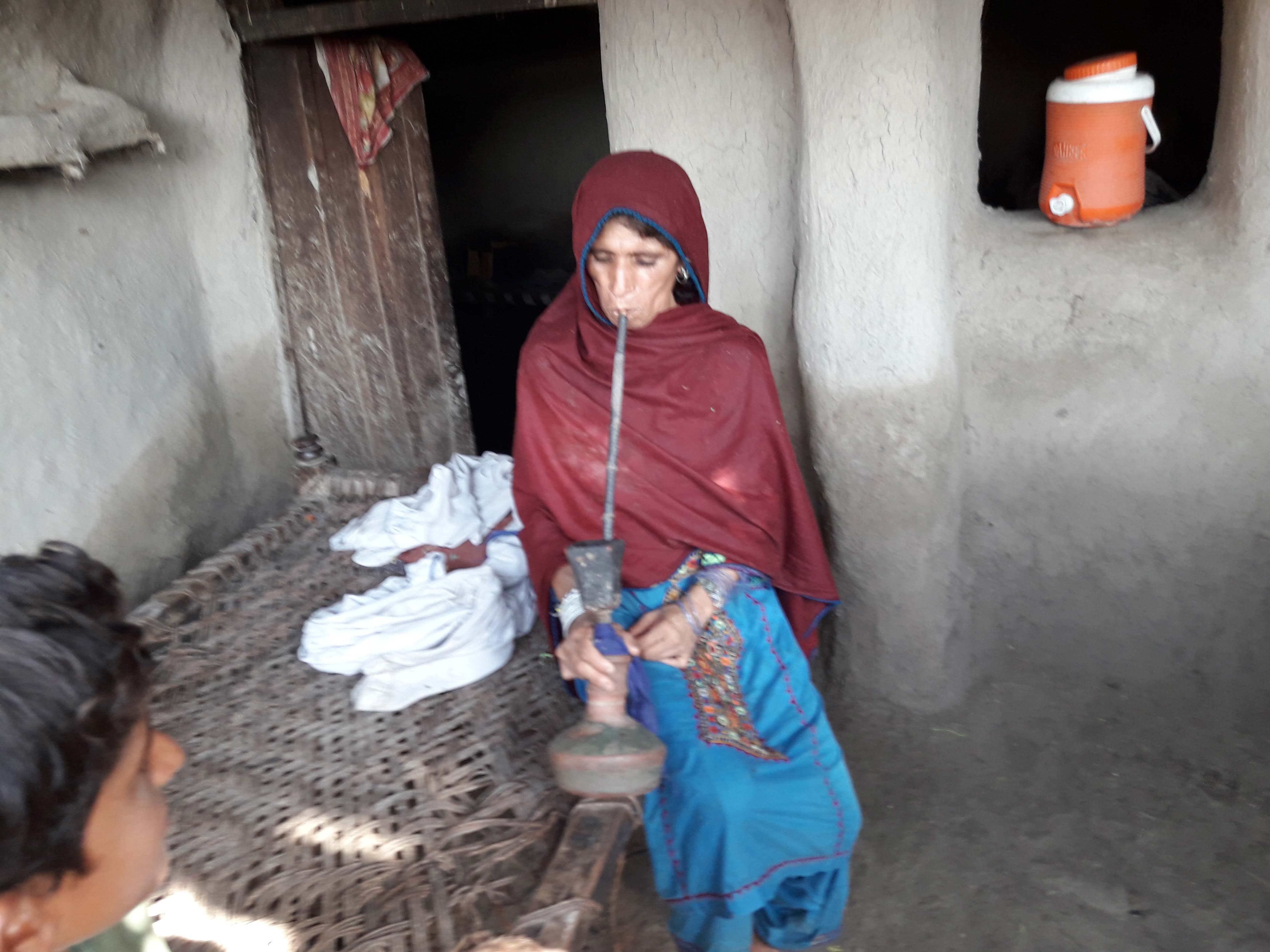 A woman in a village near Larkana prepares a hookah